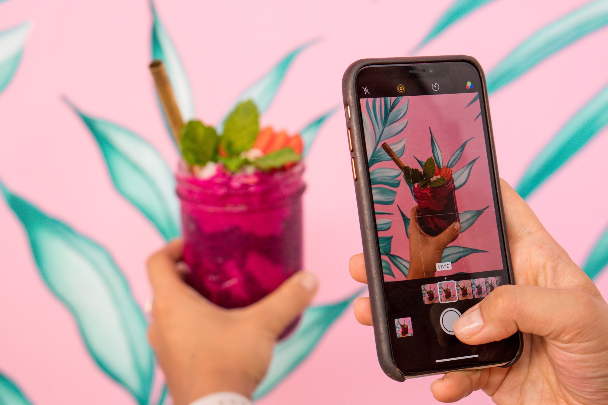 woman-taking-photo-of-the-colorful-smoothie-on-her-mobile-phone